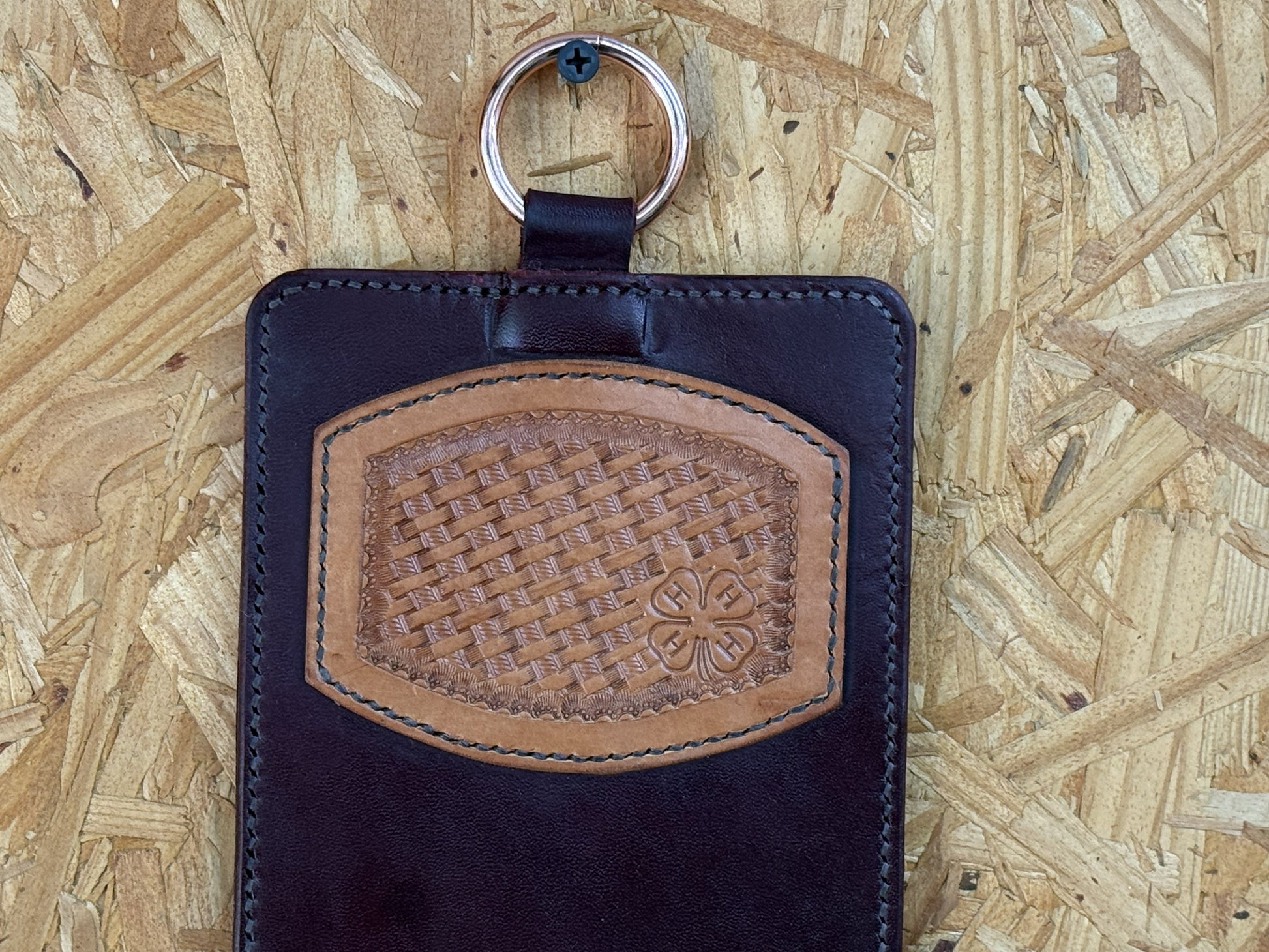 Hand-tooled basketweave leather craftsmanship on a handmade trophy buckle display.